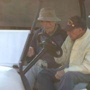 two elderly men in a golf cart